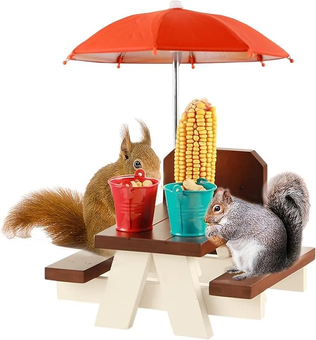 Mini picnic table with umbrella and corn cobs serving as a hilarious squirrel and chipmunk dining station